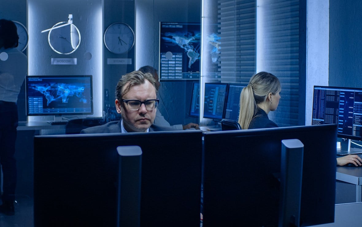 Man working with 2 screens in a government office.